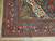 Corner detail showing coral main border, blue guard stripes, ivory selvage and hand-tied wool fringe