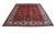 Red and ivory 10x13 Tabriz area rug displayed at an angle showing pile sheen and scale