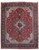 Overhead view of red Persian Tabriz rug with ivory star medallion and navy palmette border