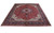 9'10" x 12'8" Tabriz rug shown at an angle, deep red field with ivory spandrels