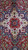 Close-up of ivory and navy central medallion with red star rosette and serrated leaves