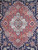 Close-up of brick red stepped medallion with ivory core, rosettes and pale blue center cartouche
