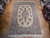 8' x 11'8" Persian Kerman rug photographed lengthwise, cream field with rose and blue flower sprays