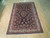 Angled floor view of hand-knotted wool Sarouk, navy field with salmon, ivory and green flowers
