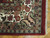 Corner detail showing ivory border, palmette scroll, red selvedge and hand-tied cotton fringe