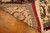 Back of the rug folded over showing dense 18/18 weave and cotton foundation on wood floor