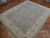 8' x 9' Pakistani Chobi rug photographed at an angle, ivory border framing the soft sage field