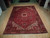 9'4" x 12'7" Persian Heriz rug displayed full length on light hardwood showroom floor