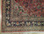 Corner detail showing multiple floral guard stripes, sage spandrel, white fringe and dense wool pile