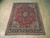 7'2 x 9'4 Sarouk rug lying flat on pale wood floor showing full floral field
