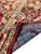 Back of the rug folded to reveal blue cotton weave and tight knot structure