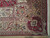 Corner detail of ivory garden border, red rosette medallion and hand-finished selvage with fringe