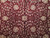 Close-up of rosette, palmettes and scrolling vines in ivory, rose and sage on maroon