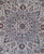 Close-up of the layered ivory medallion with navy palmettes, olive leaves and fine wool knotting