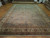 Angled floor view showing all-over floral field, ivory main border and soft sage green tones