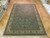 Teal-blue hand-knotted wool rug displayed on parquet floor in our Freeport New York warehouse