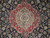 Close-up of the red and ivory center medallion ringed by curling camel palmettes on navy