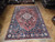 Semi antique 6'11" x 10'2" Tabriz rug displayed on parquet showroom floor at Rugs.net