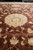 Low angle shot highlighting lustrous wool sheen and large beige rosette on brown field