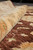 Rolled edge of the rug showing pile depth, hand-knotted density and soft ivory border wool