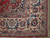 Corner detail of the 10'5" x 15'5" Persian rug showing ivory border, navy leaves and fringe