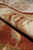 Rolled edge of the Indian wool rug showing pile depth, side finish and reverse knots