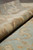 6x9 wool Oushak rug rolled at the edge, showing dense knotting and 3/8 inch pile