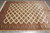 Angled overhead view of geometric gul lattice filling the cream field of this hand-knotted rug