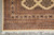 Corner detail with ivory fringe, layered borders and geometric medallions on the cream ground
