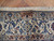 Woven signature cartouche in the tan border of this signed Persian Nain wool and silk rug