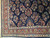 Corner detail showing ivory guard stripes, brick red main border and coral flower bouquets