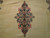Close-up of navy and rose floral medallion woven on the open ivory field