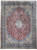 Full-length view of red floral Persian Kerman rug with navy border and light blue spandrels