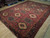 Angled view of the deep red field, three columns of cream diamond medallions and indigo border