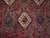 Close-up of hand-knotted wool pile showing ivory diamond medallion, teal star motifs and geometric filler ornaments