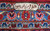 Woven signature cartouche in ivory on light blue border of this signed Kashan rug