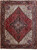 Dark red Persian Heriz rug with ivory corner spandrels and navy stepped geometric medallion, shown flat