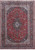 8'6" x 11'11" Persian Kashan rug with red floral field and navy lobed medallion