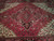 Close-up of the stepped central medallion with pendants, ivory outlines and deep charcoal accents on red