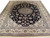 Full view of 6'7" x 10' Persian Nain rug with black field and ivory floral border