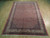 6'7" x 9'4" Bijar rug photographed at an angle, showing stepped corners and ivory fringe ends