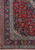 8x11 Kashan rug corner detail showing navy floral border, ivory guard stripes and hand-knotted fringe
