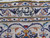 Woven signature cartouche in dark navy script set into the top border of the rug