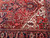 Corner detail showing ivory spandrel, serrated leaves and the multi-banded border of this wool Heriz rug