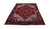Angled floor view of the 6'11" x 10'3" hand-knotted wool Heriz rug on white