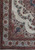 Corner detail showing ivory main border, floral guard stripes and rose spandrel on hand-knotted wool