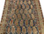Close view of repeating paisley boteh rows with serrated outlines and small tribal animal figures