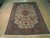 8x12 Persian Tabriz rug angled on hardwood, ivory ground with salmon floral main border