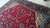 Hand-knotted wool Sarouk rug photographed on floor, showing pile sheen and ivory corner spandrel