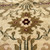 Macro close-up of an 8 petal rosette in camel and crimson on ivory wool
